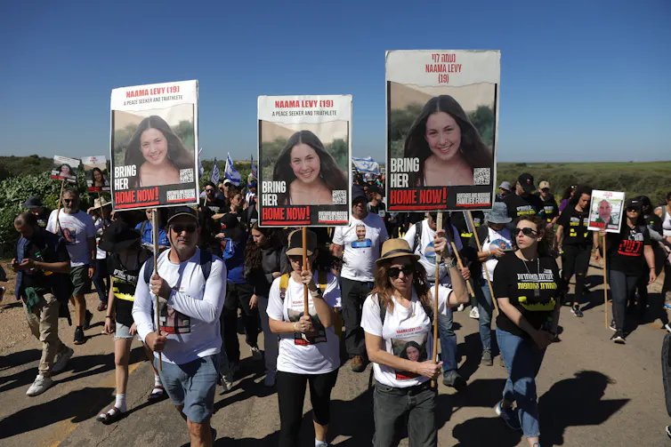 Israelis march with placards with pictures of hostages still held by Palestinians