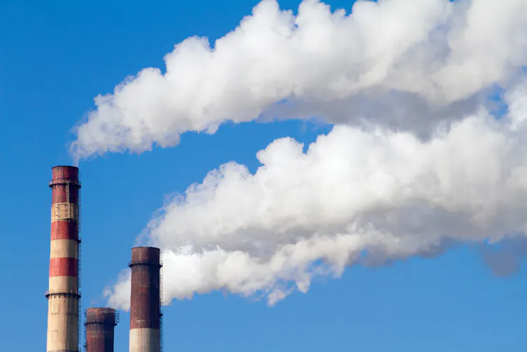 Three chimneys spewing white smoke.
