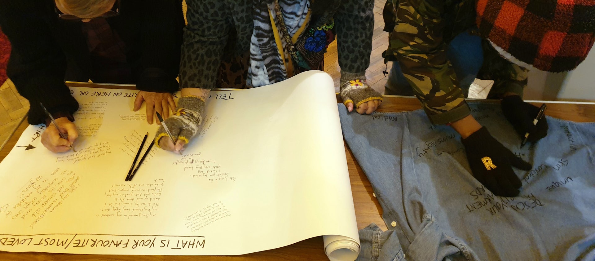 Hands of a person in the picture bending over paper on the table