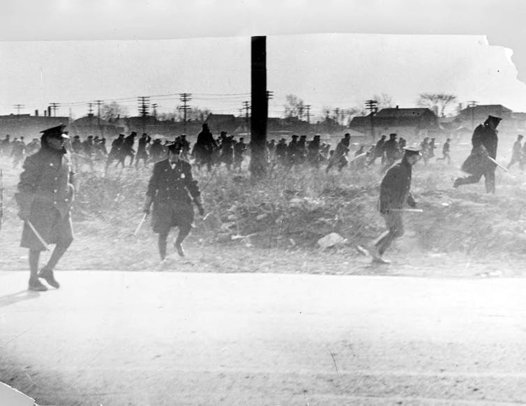 La policía con murciélagos sigue a los manifestantes de la Marcha del Hambre el 7 de marzo de 1932.