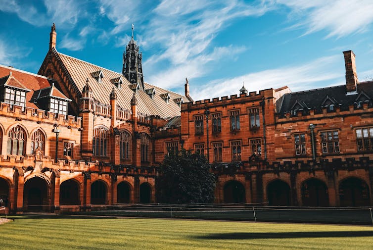 The main quadrangle at Sydney University. An old sandstone building with grass in the middle.