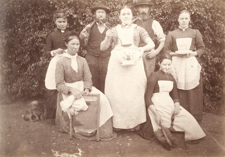 Sepia photograph, five women and two men.