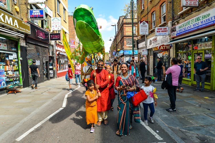 A family takes part in a colourful street festival.