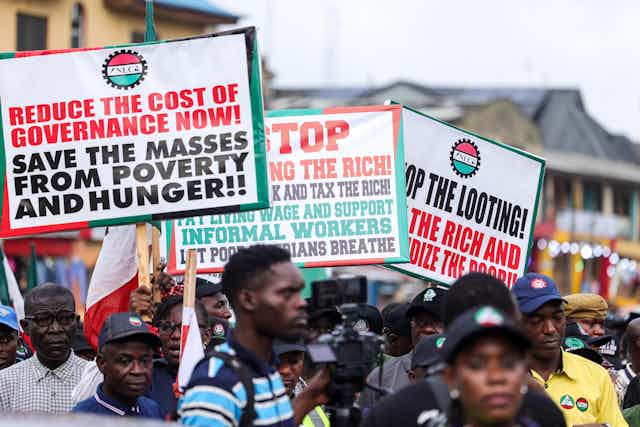 A group of Nigerian men display placards during a protest.