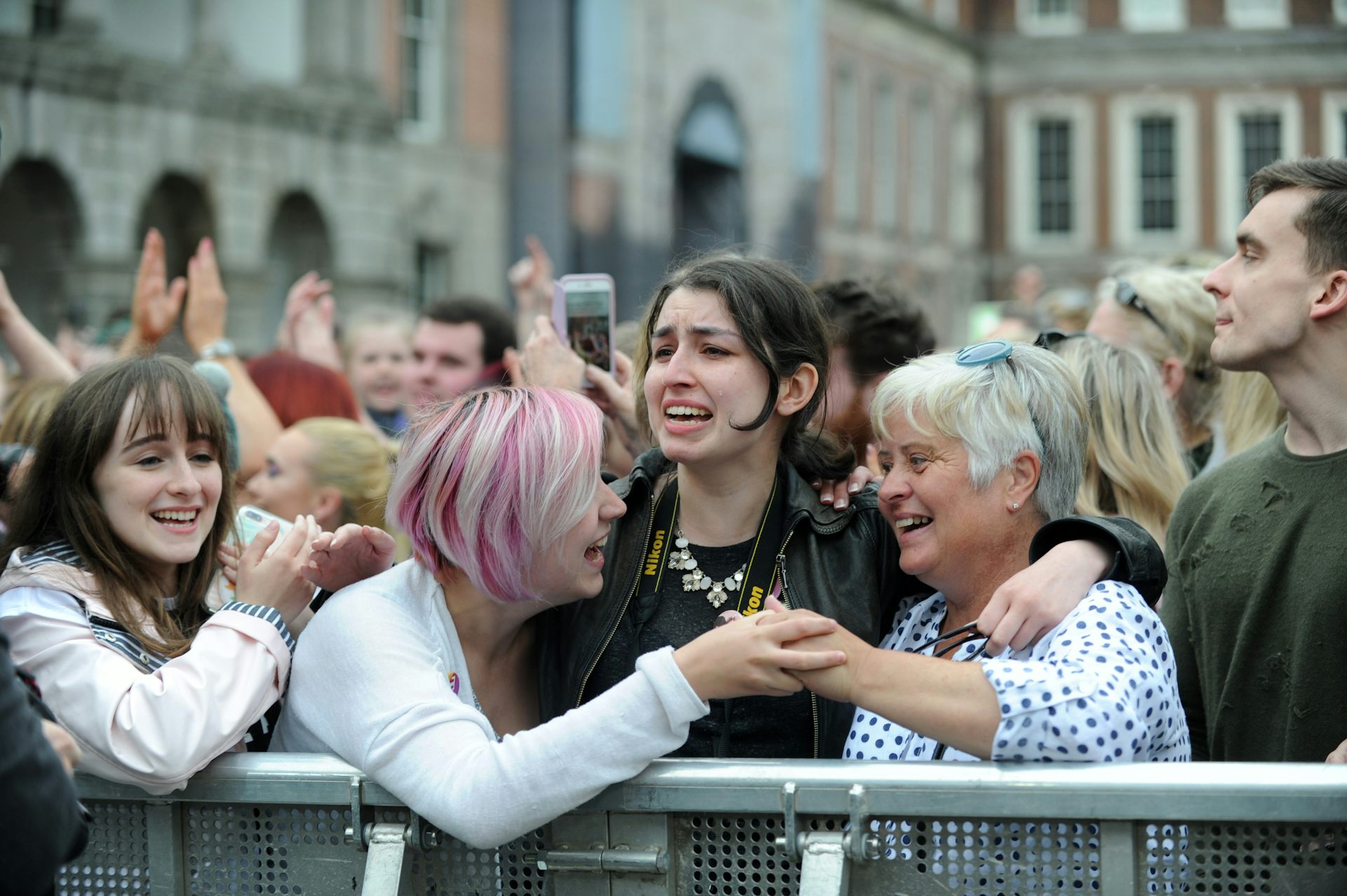 Women hugging each other in a crowd.