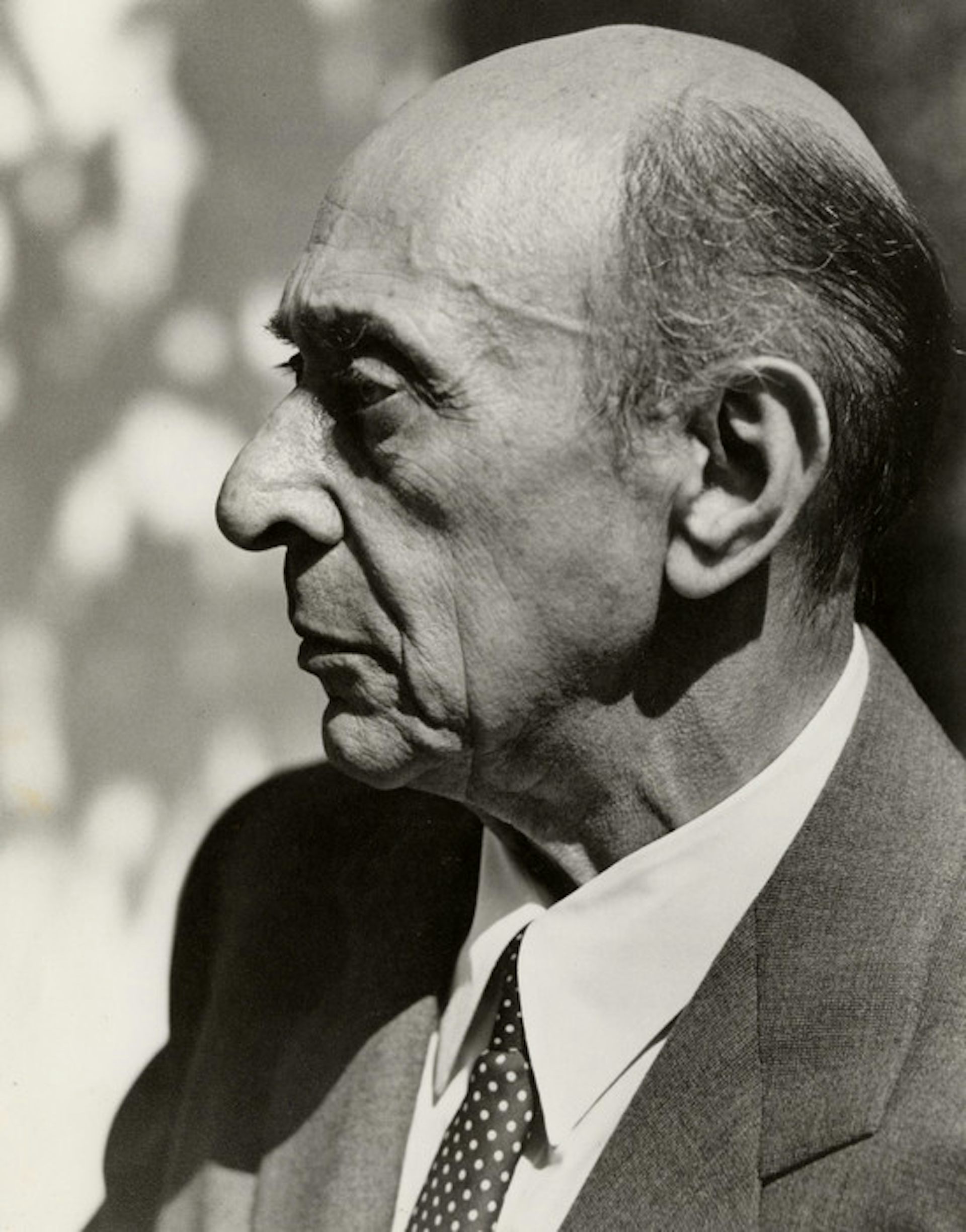 A man in profile in a suit and tie.