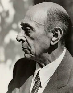 A man in profile in a suit and tie.