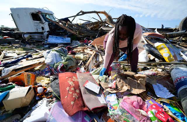 A woman sorts through belongs at a family member's home after a tornado hit Rolling Fork, Mississippi, on March 26, 2023.