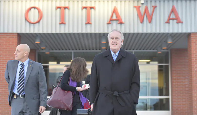 Mulroney walking with Ottawa sign in background