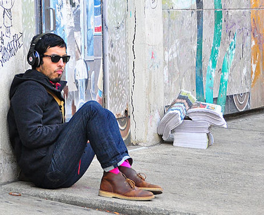 hipster sitting on sidewalk