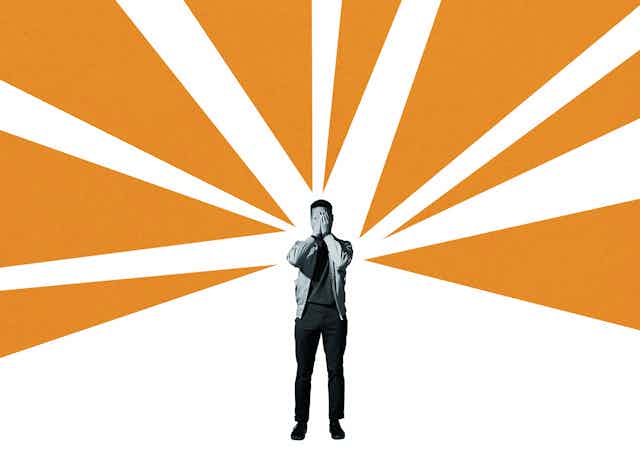 A stressed man, covering his face with his hands, stands amid illustrated orange rays and a white background.
