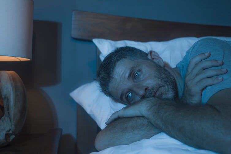 Man lays awake in bed