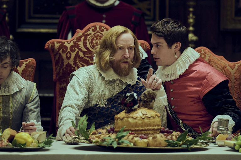 A young man whispers in the ear of the king