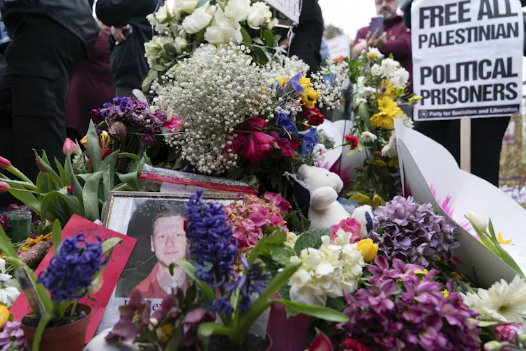 flowers surround a photograph of a young man.