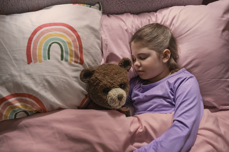 Pyper Braun as Alice with Chauncey the bear in bed.