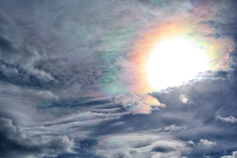 O Sol surgindo de trás de nuvens