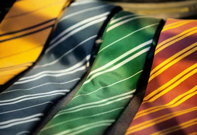 Four striped ties in different colours in a row. 