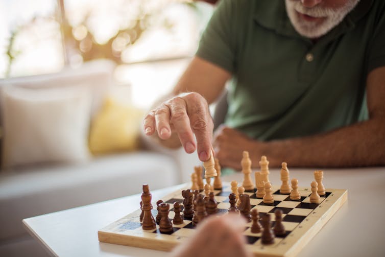 older man playing chess