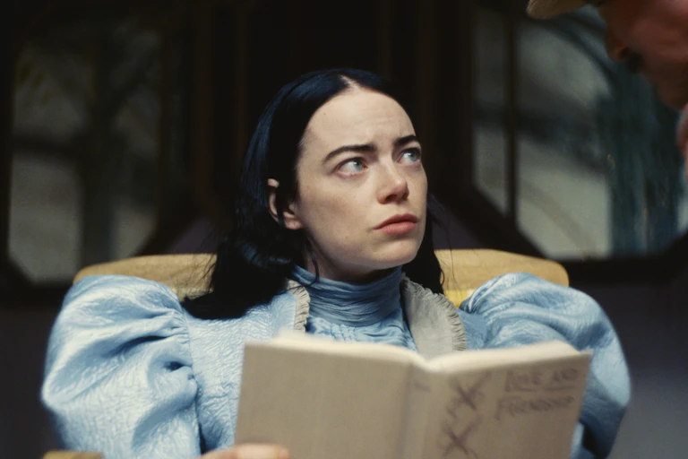woman with dark hair looks up confused from book (film still)