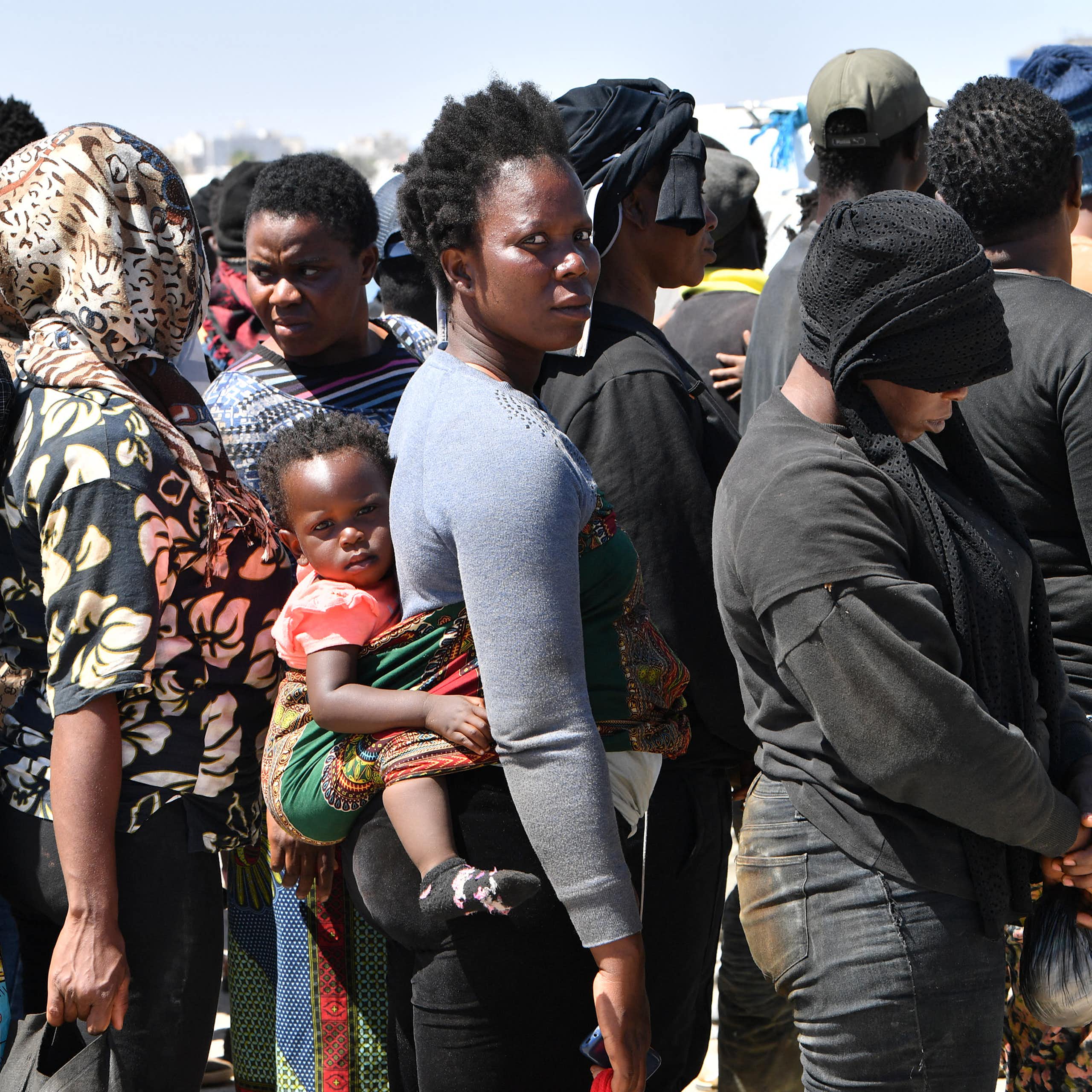 Des migrants d'origine africaine tentant de fuir vers l'Europe débarquent à Sfax d'un navire appartenant aux garde-côtes tunisiens, après avoir été interceptés par ces derniers en mer, le 10 août 2023.