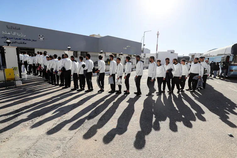 Egyptian migrants line up to be deported in Tripoli, Libya, on 12 December 2023. The Libyan authorities announced that 964 illegal immigrants, including 664 Egyptians and 300 Nigerians, have been sent back to their country