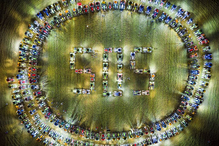 An aerial view of farm vehicles spelling out 'SOS'.
