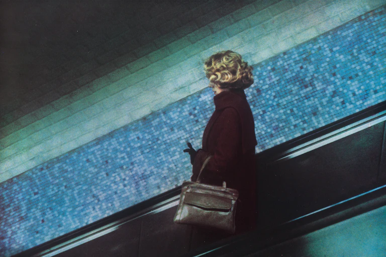 A woman on Paris's metro going down an escalator.