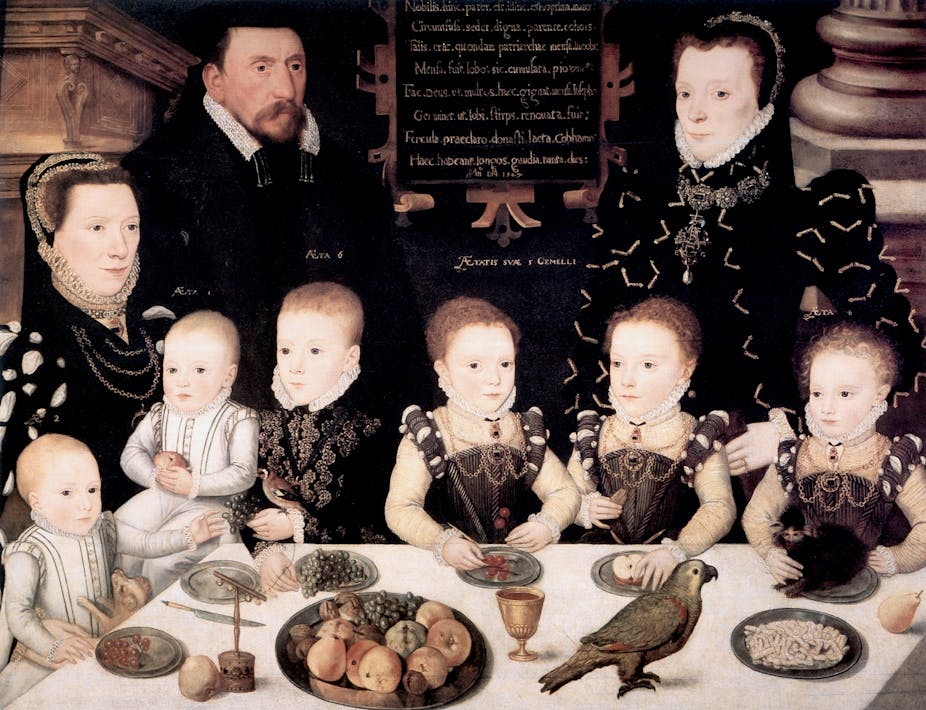 A Tudor painting of a family sitting around the dinner table