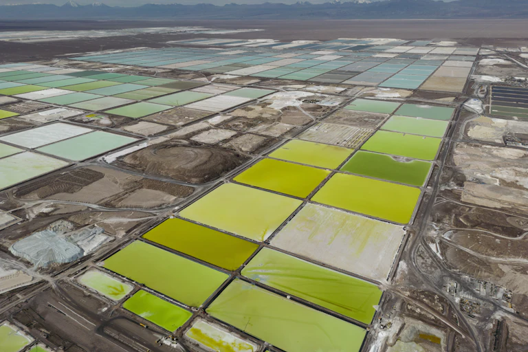 Poças de líquido verde e azul são vistas em uma paisagem árida