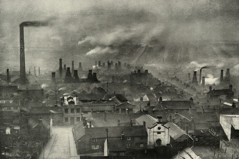 Smoke rises from many chimneys in an industrial area of England.