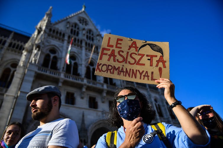 A demonstrator holding a placard that in Hungarian says 'Down with the Fascist government.'