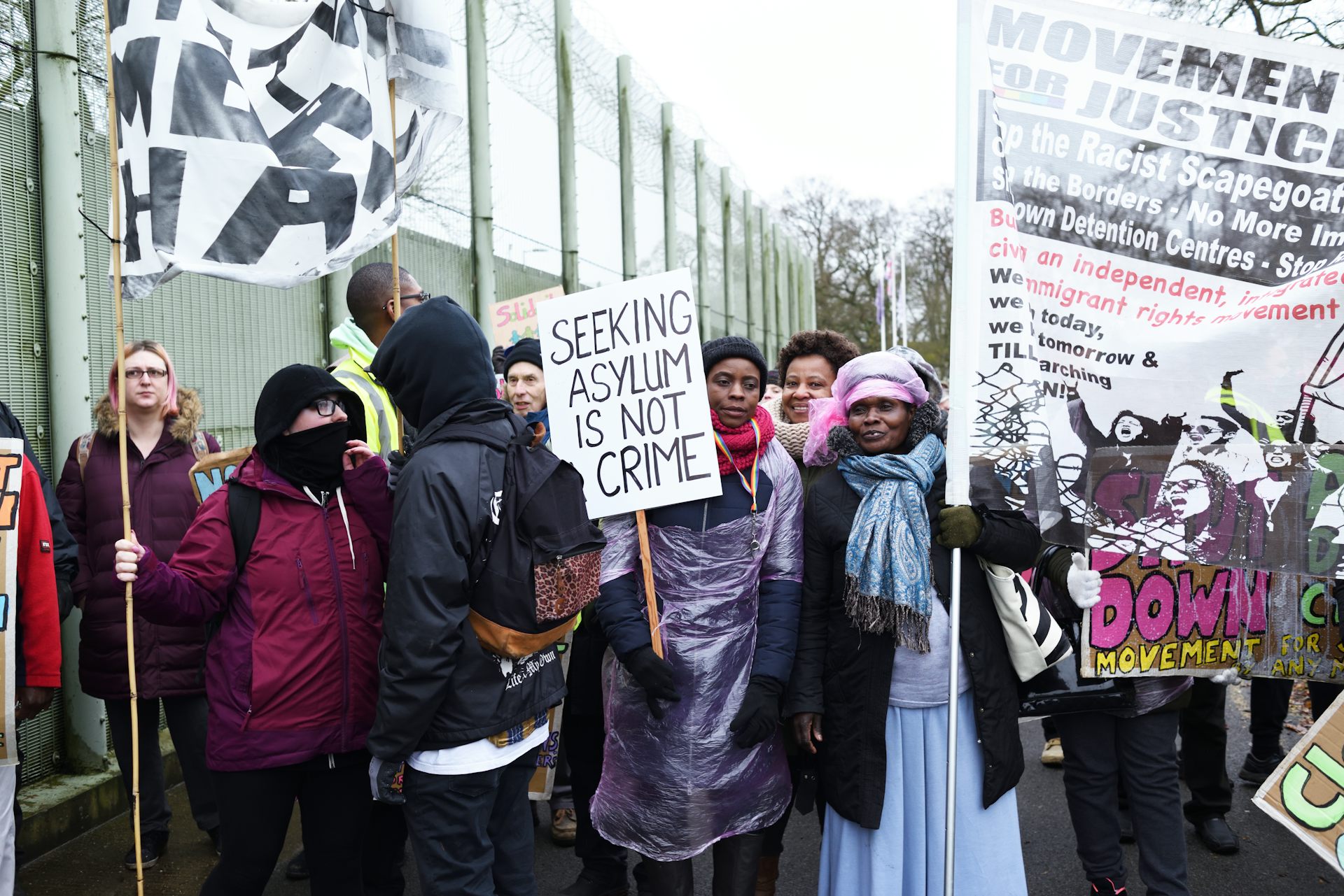 Protestors hold up posters.