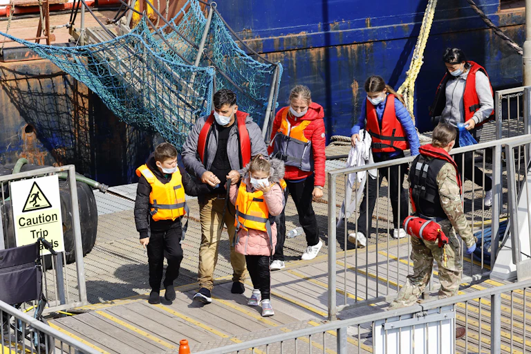 People in life jackets on a jetty.