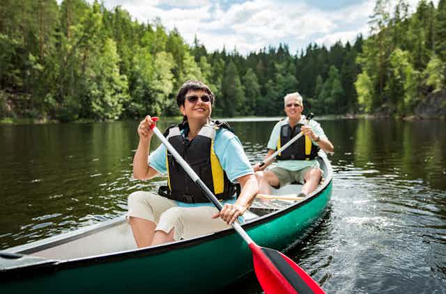 A man and a woman canoeing in Finland