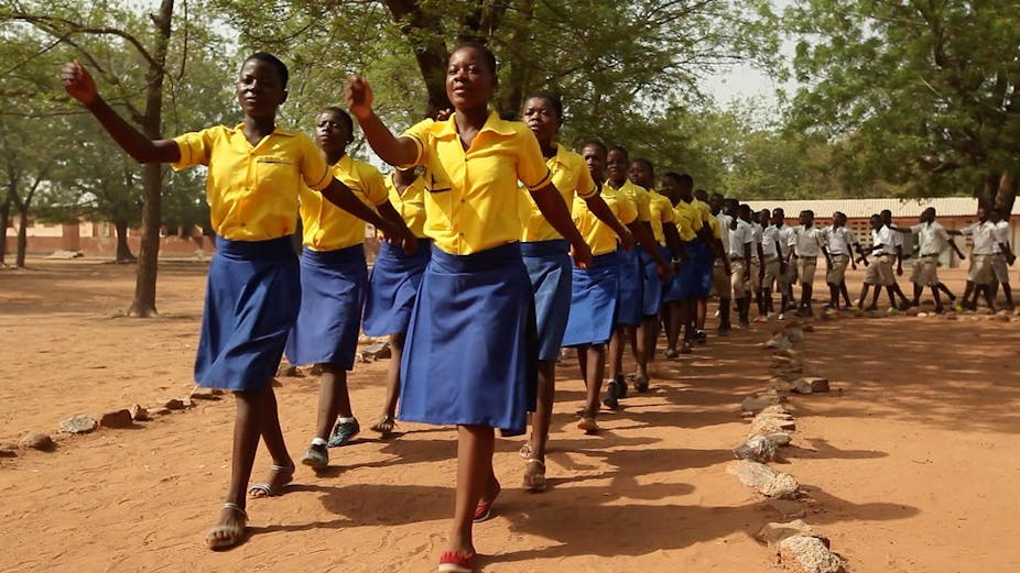 A group of girls in yellow marching  