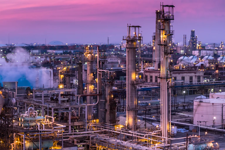 Industries lit up near the Port of Los Angeles at dusk.