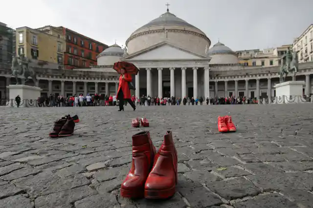 Red shoes dot the pavement in a cobbled square.