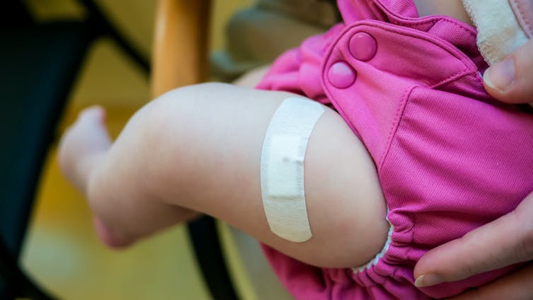 A baby's leg with a bandaid on it.