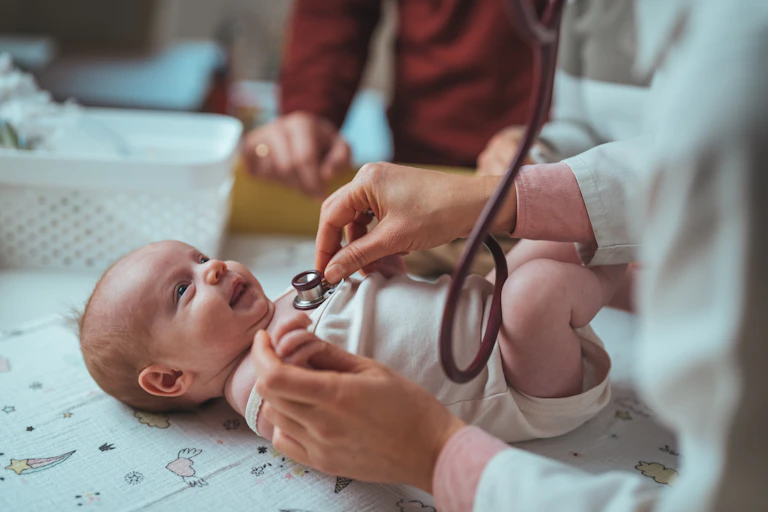 Baby giggles at doctor listening to their chest