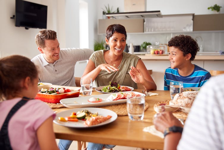 Mother talks to her family at the dinner table