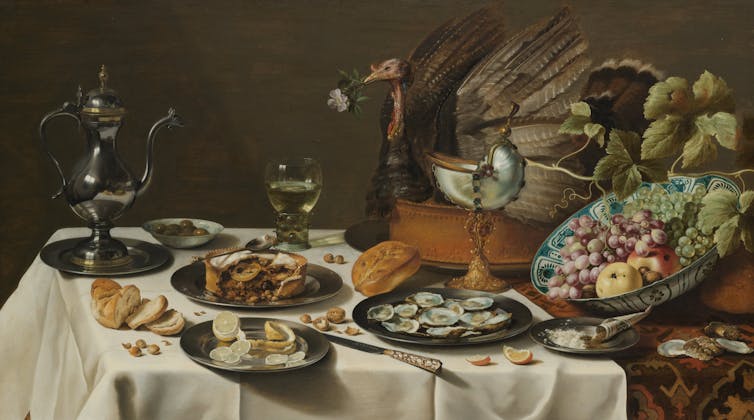 An old painting of a table filled with ornate looking food.