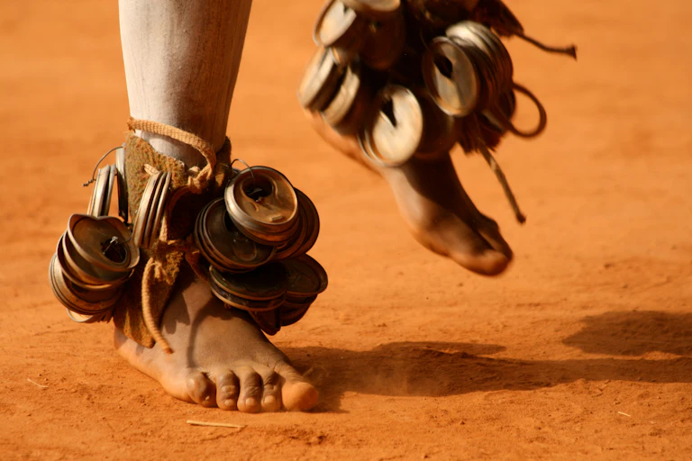 Feet with can lids tied around the ankles as rattles.