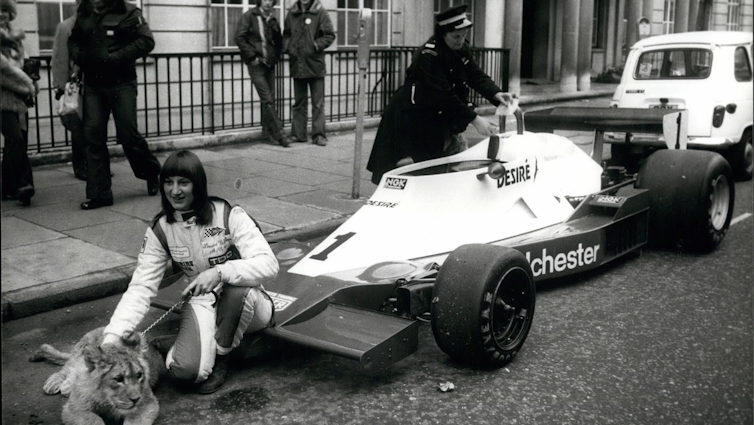 Desiré Wilson with a tiger and her racing car.