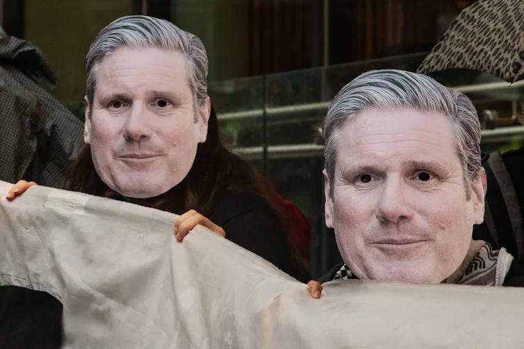 People wearing masks of Keir Starmer's face.