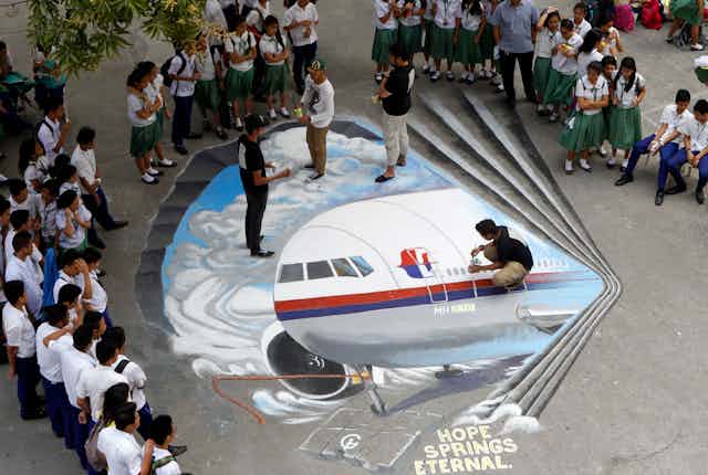 Filipino artists paint an image of Malaysia Airlines Flight MH370, to express hope for the passengers on 17 March 2014.