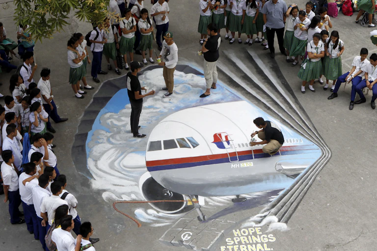 Filipino artists paint an image of Malaysia Airlines Flight MH370, to express hope for the passengers on 17 March 2014.