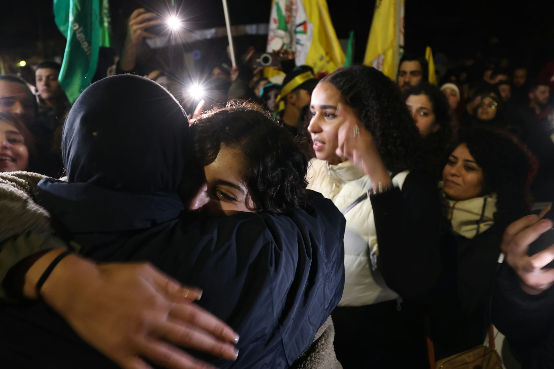 Palestinian prisoners released in November under the terms of a hostage swap hug and kiss their families