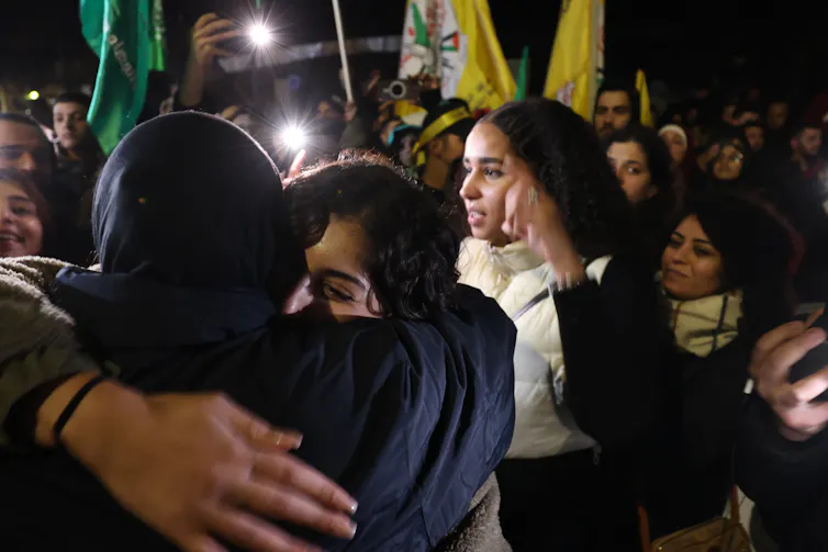 Palestinian prisoners released in November under the terms of a hostage swap hug and kiss their families