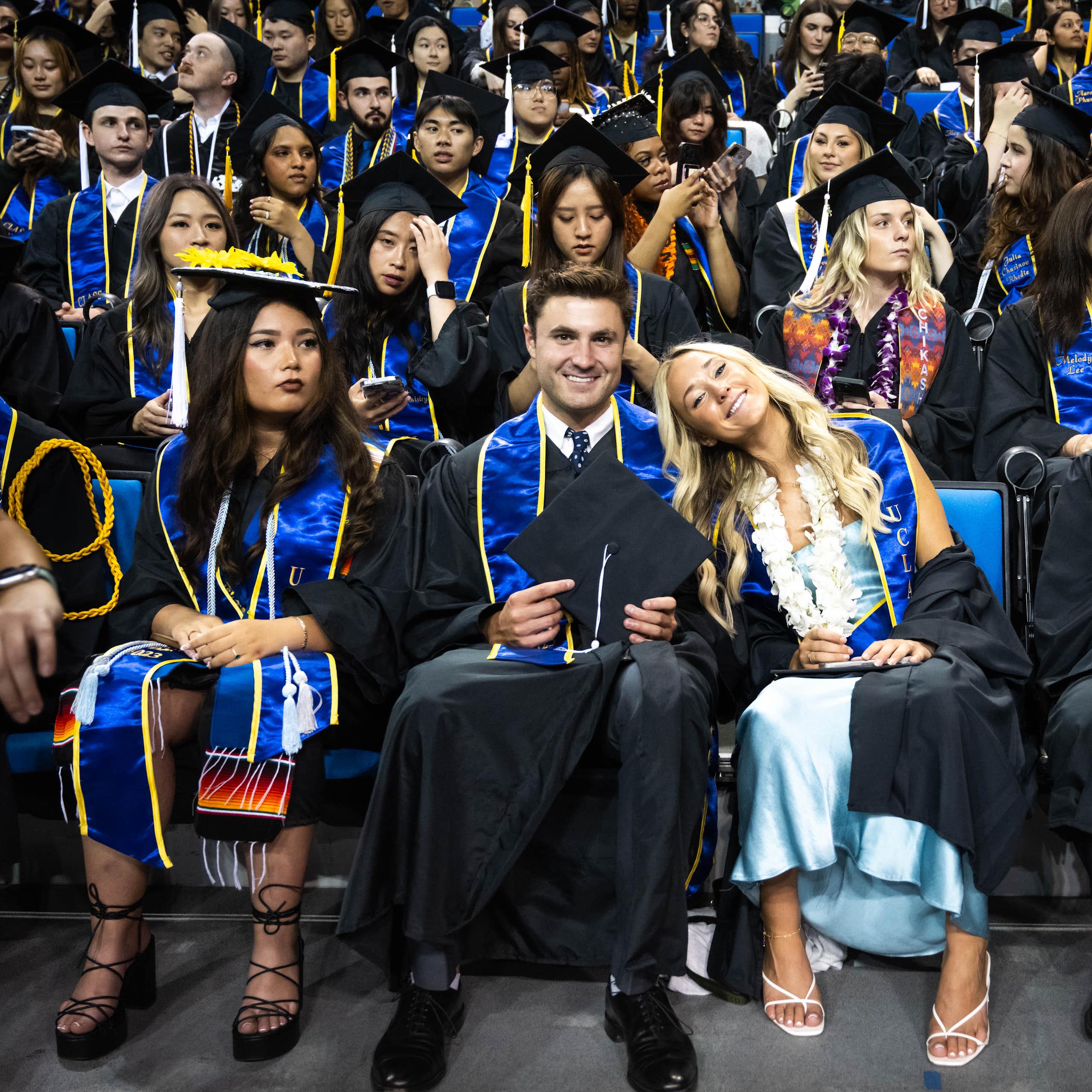 College graduates at a ceremony in their caps and gowns.