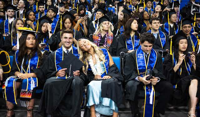College graduates at a ceremony in their caps and gowns.